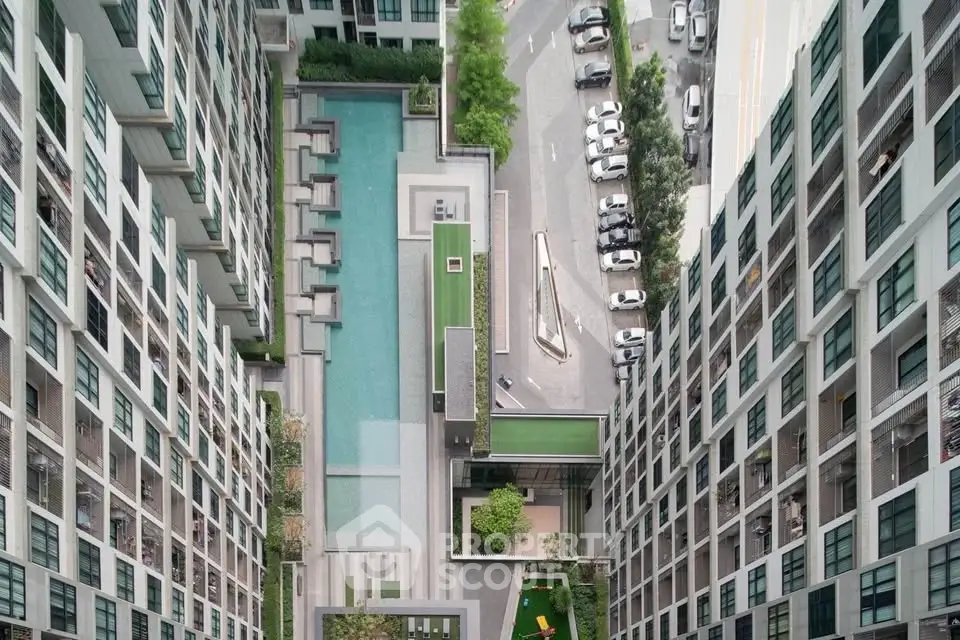 Stunning aerial view of modern apartment complex with pool and garden amenities.