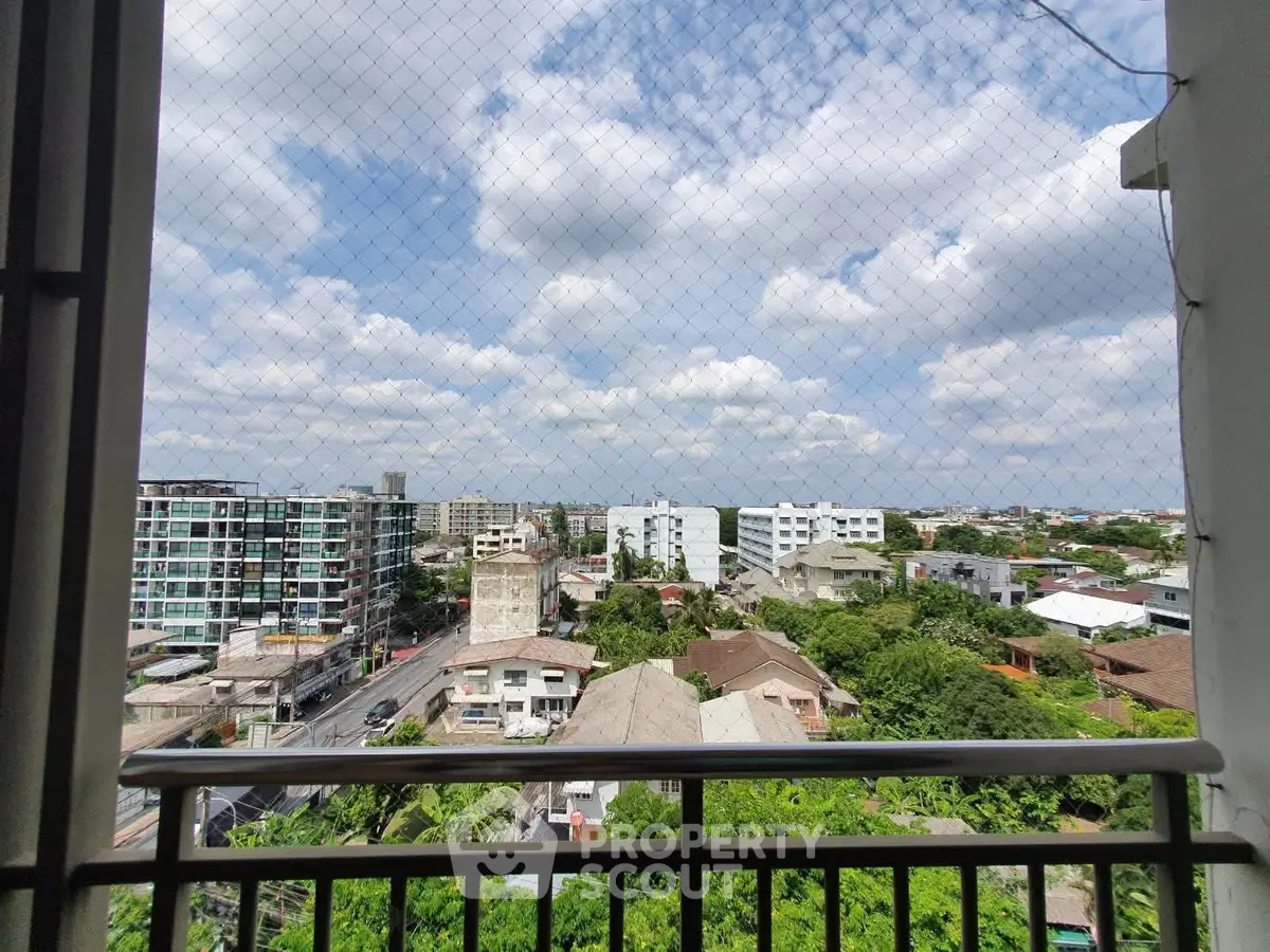 Stunning cityscape view from a high-rise balcony with lush greenery and modern buildings.