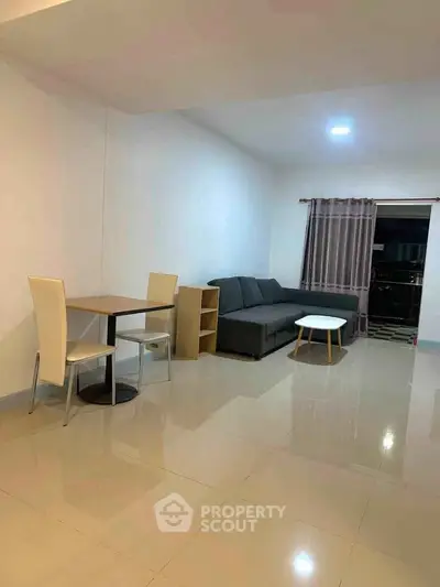 Spacious living room with modern furniture and tiled flooring, perfect for relaxation and entertainment.