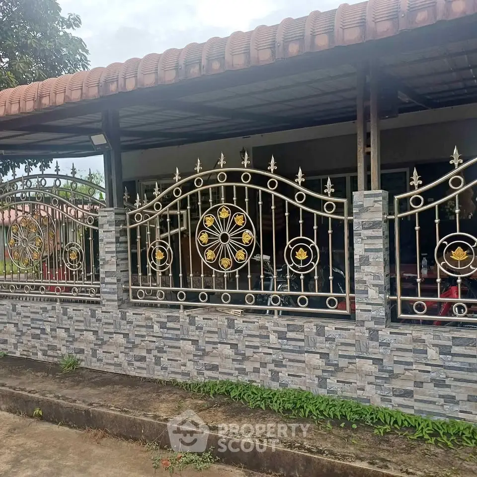 Charming home exterior with decorative wrought iron fence and tiled roof