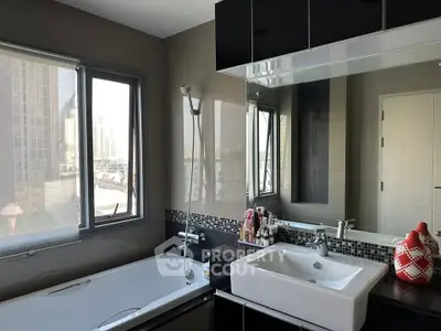 Modern bathroom with city view, featuring sleek black and white design and a spacious bathtub.
