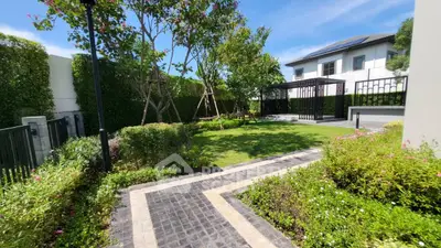 Beautiful garden with lush greenery and modern house in the background, perfect for relaxation.