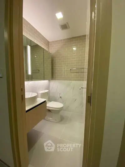 Modern bathroom with sleek design and neutral tones, featuring a stylish vanity and contemporary fixtures.