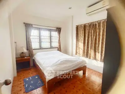 Cozy bedroom with natural light, featuring a comfortable bed and air conditioning, perfect for relaxation.