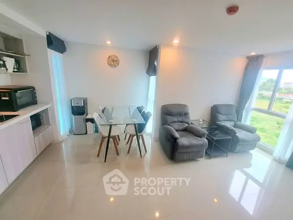 Modern living room with sleek furniture and large windows offering natural light and scenic views.