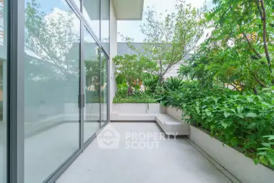 Spacious modern balcony with lush greenery and glass doors