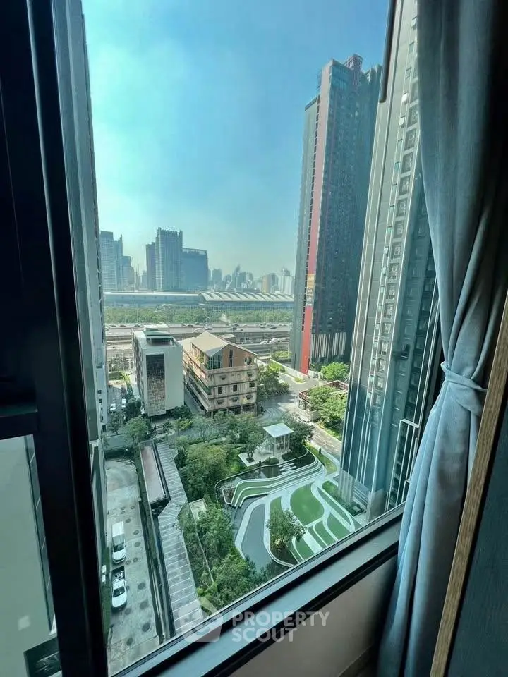 Stunning urban view from high-rise window overlooking cityscape and modern architecture.