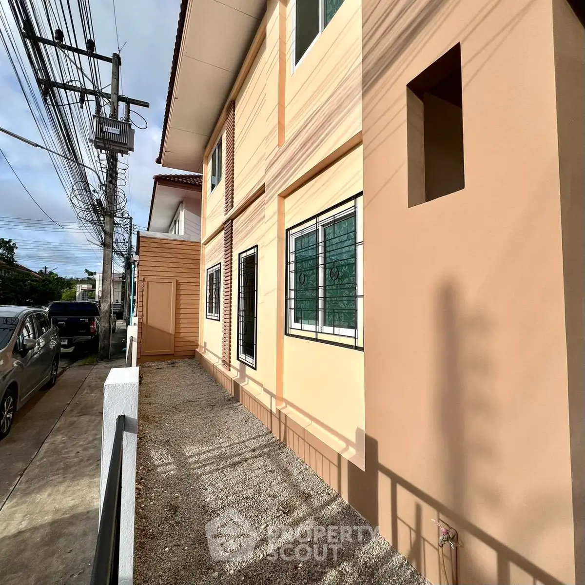 Modern residential building exterior with beige facade and large windows, showcasing urban living.