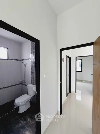 Modern apartment hallway with bathroom and sleek tile flooring