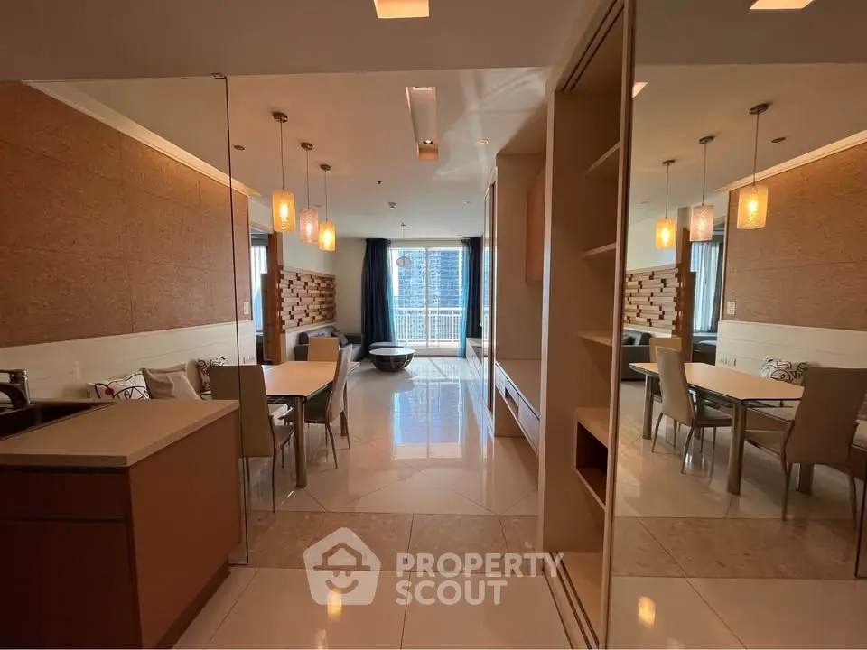 Modern open-plan living and dining area with stylish lighting and large windows.