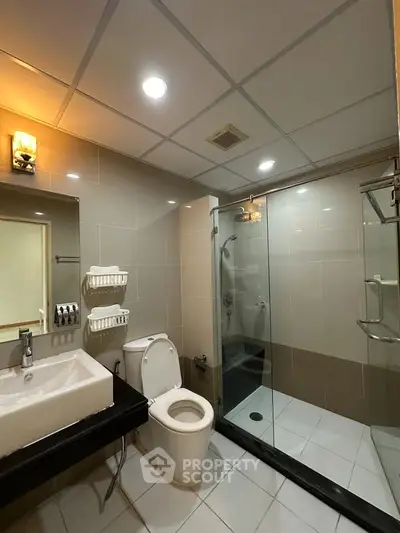Modern bathroom with glass shower and sleek fixtures in a contemporary home.