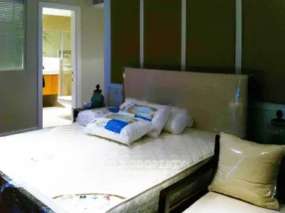 Spacious bedroom with modern decor and ensuite bathroom, featuring a comfortable bed and stylish furnishings.