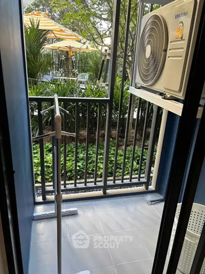 Charming balcony with garden view and air conditioning unit, perfect for relaxation.