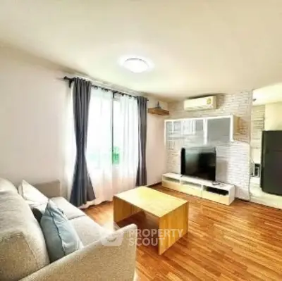 Bright and cozy living room with modern decor and wooden flooring.