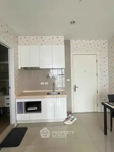Charming kitchen with modern cabinets and playful polka dot wallpaper