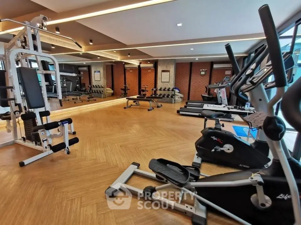 Spacious modern gym with state-of-the-art fitness equipment and mirrored walls.