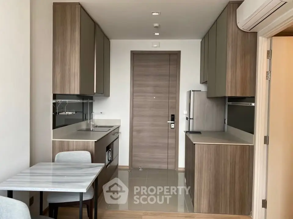 Modern kitchen with sleek cabinetry and dining area in stylish apartment