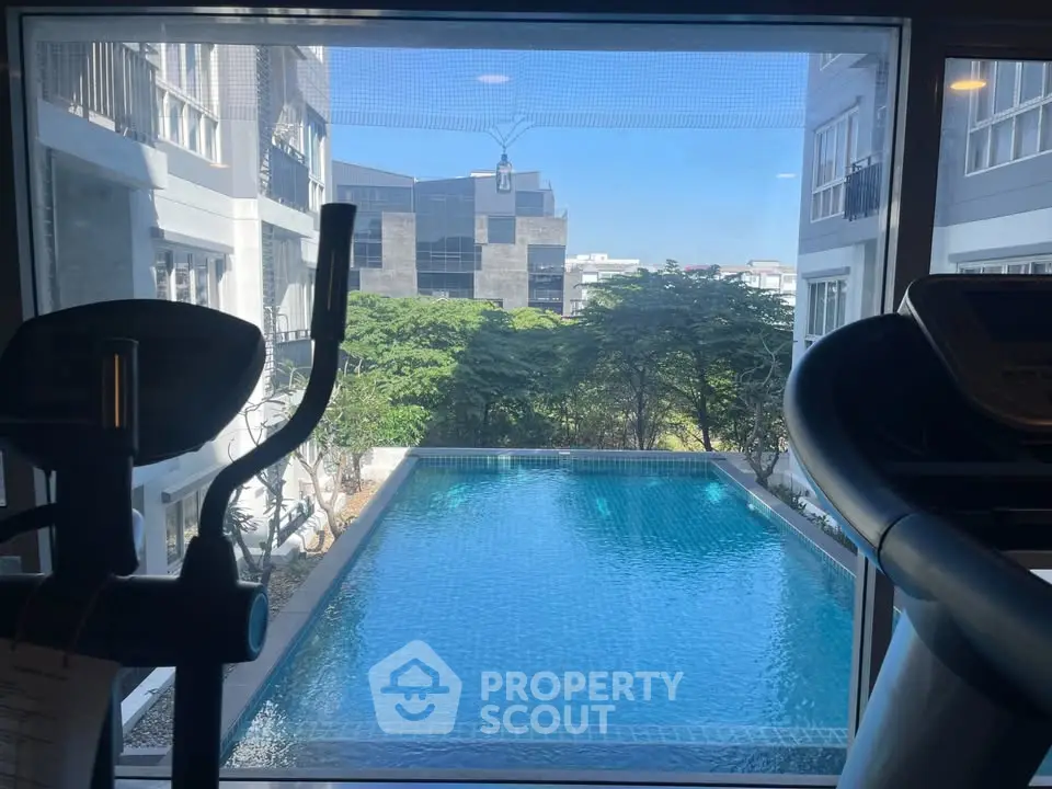 Modern gym with pool view in luxury apartment complex