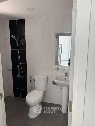 Modern bathroom with sleek fixtures and a stylish black accent wall.
