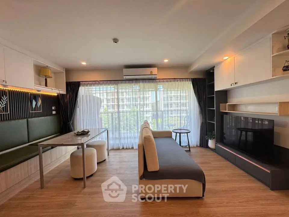 Modern living room with large windows and stylish furniture in a bright apartment.