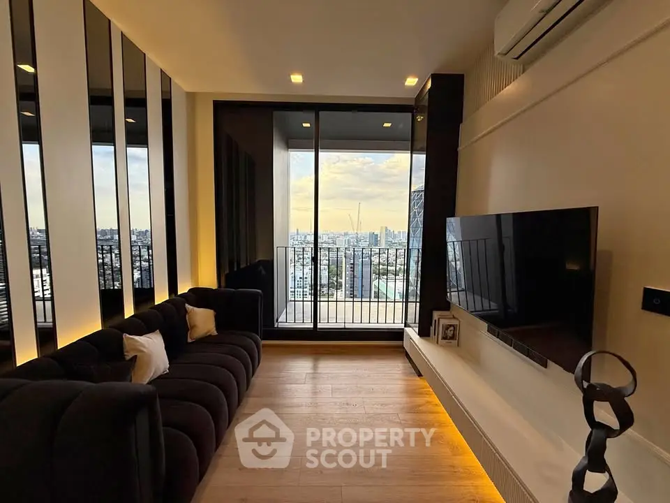 Modern living room with city view, sleek black sofa, wall-mounted TV, and floor-to-ceiling windows.