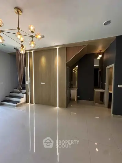 Modern living room with elegant lighting and sleek design, featuring glossy floors and stylish wall accents.
