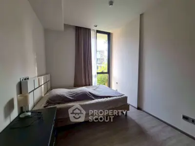 Spacious bedroom with modern design and large window offering natural light.