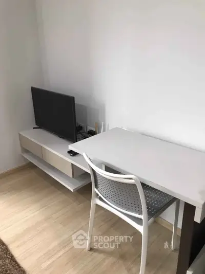 Modern study area with sleek desk, chair, and TV in minimalist design.