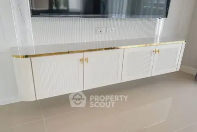 Elegant modern living room with sleek white TV cabinet and glossy floor tiles.