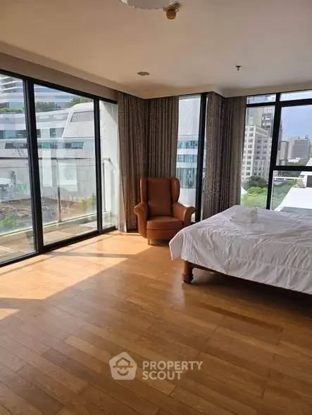 Spacious corner bedroom with floor-to-ceiling windows and city view