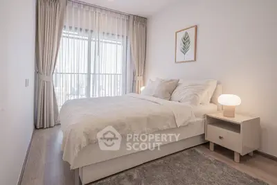 Cozy and bright bedroom with modern decor and large window for natural light.