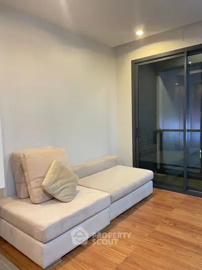 Modern living room with cozy beige sofa and sliding glass doors