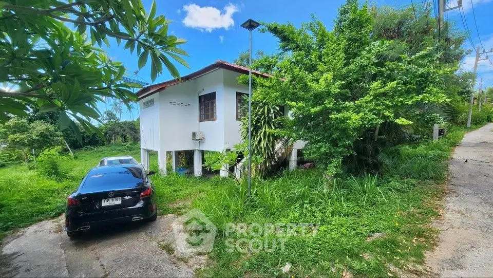 Charming countryside house with lush greenery and ample parking space, perfect for nature lovers.