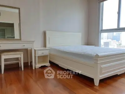 Spacious bedroom with elegant white furniture and city view, perfect for urban living.