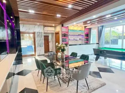 Luxurious modern living room with elegant dining area and pool table, featuring stylish decor and ambient lighting.