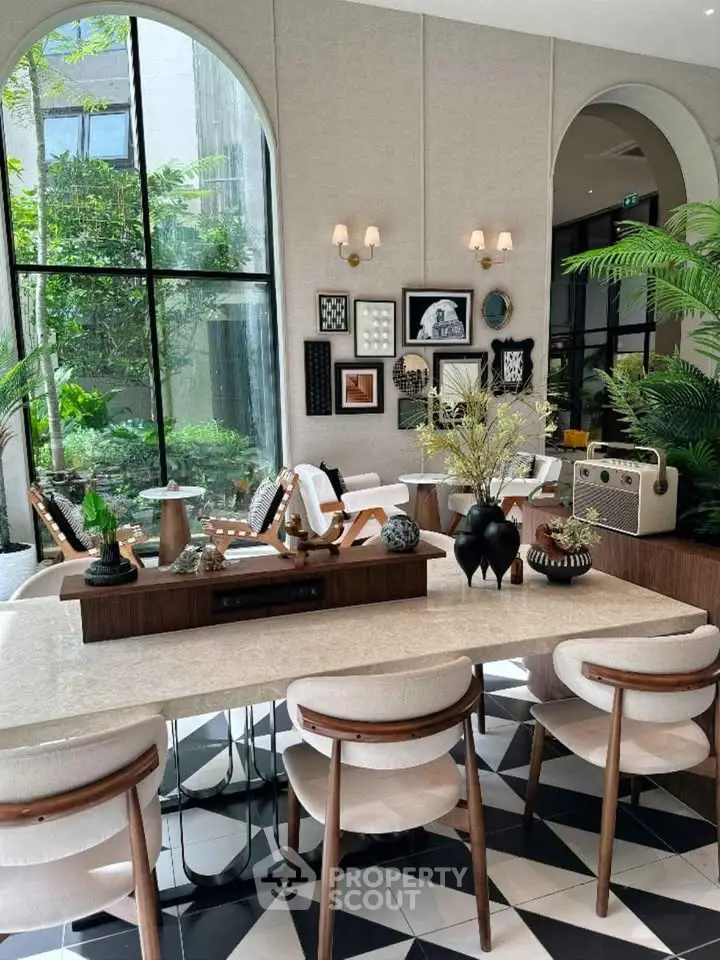 Luxurious modern living room with elegant decor and large windows overlooking lush greenery.