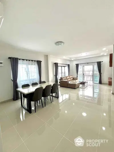 Spacious modern living room with elegant dining area and large windows.