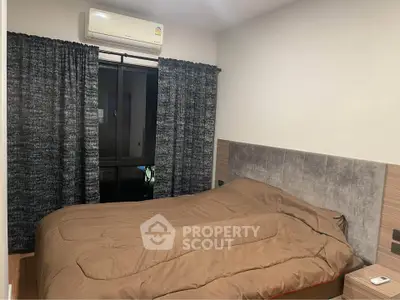 Cozy bedroom with modern decor and air conditioning, featuring a comfortable bed and stylish curtains.