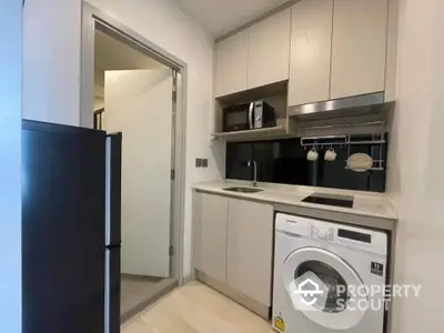 Modern compact kitchen with washing machine and sleek cabinetry