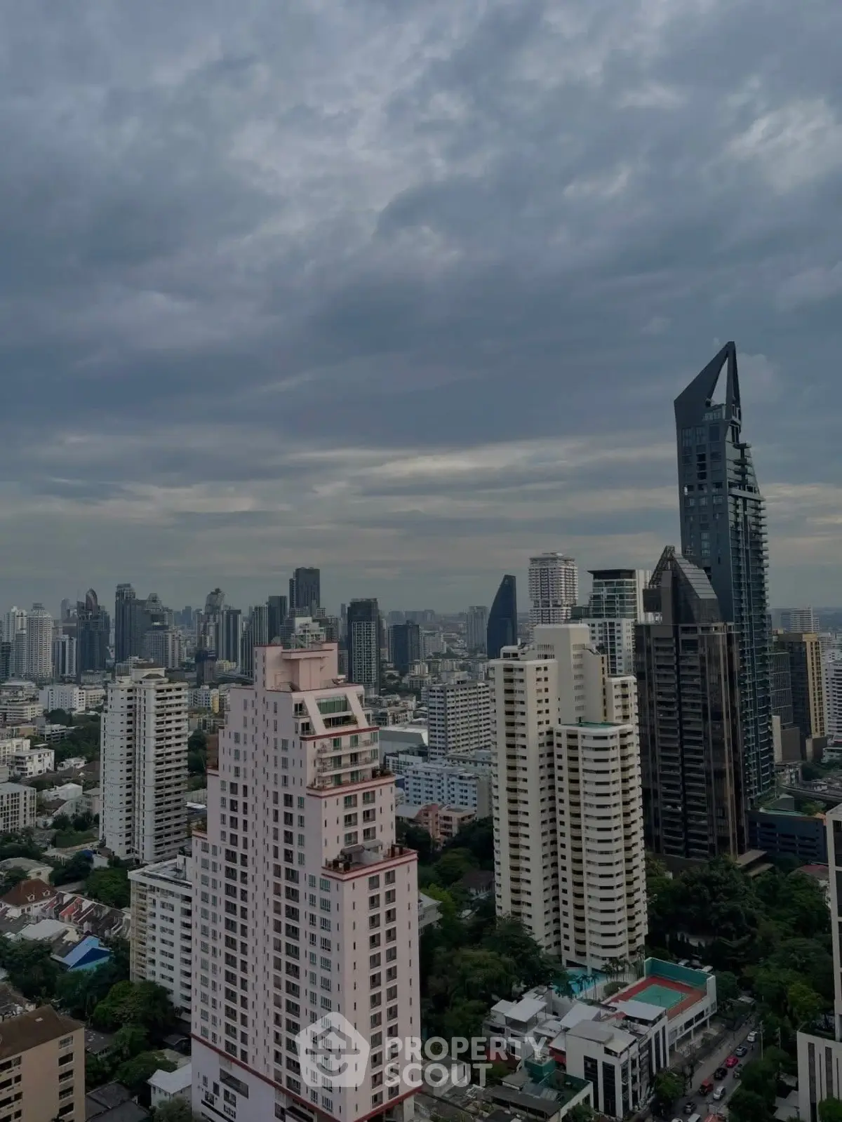 Stunning cityscape view showcasing modern skyscrapers under a dramatic cloudy sky, perfect for urban living.