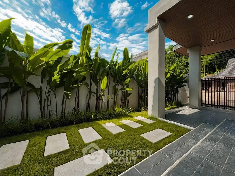 Modern outdoor garden with stepping stones and lush greenery under a clear blue sky.