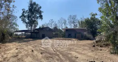 Expansive rural property with rustic buildings and open land, ideal for development or agricultural use.