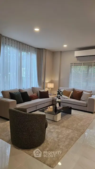 Elegant living room with modern furniture and large windows, perfect for relaxation and entertaining.