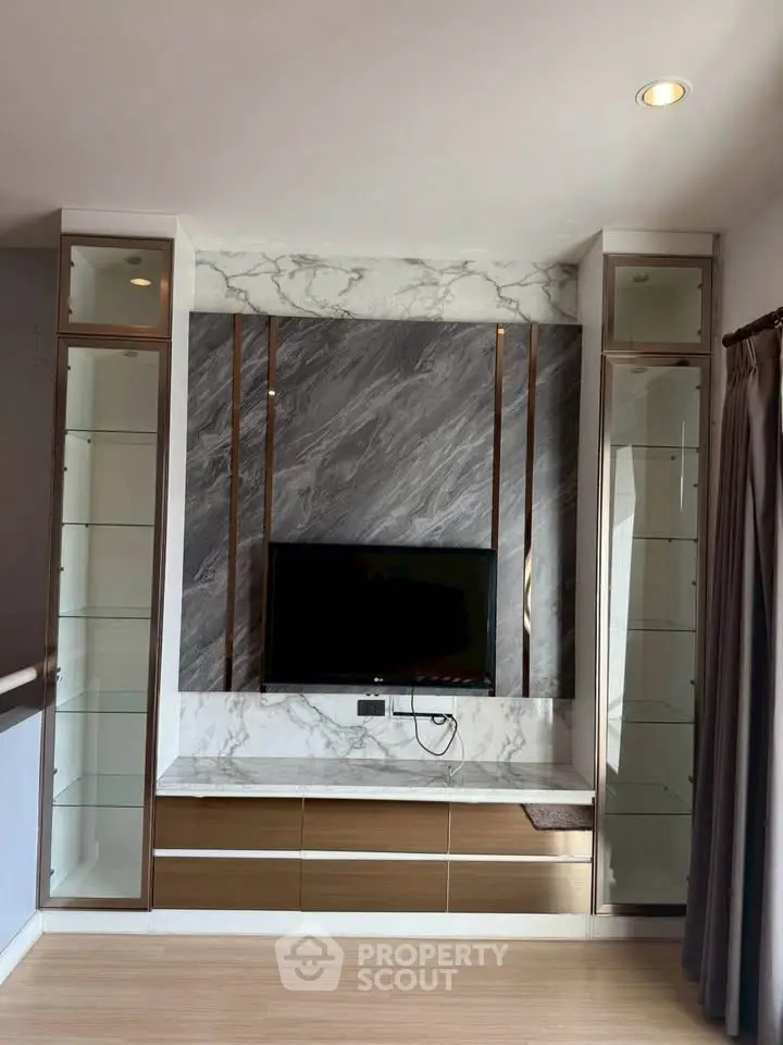 Modern living room with elegant marble TV wall and sleek glass shelving