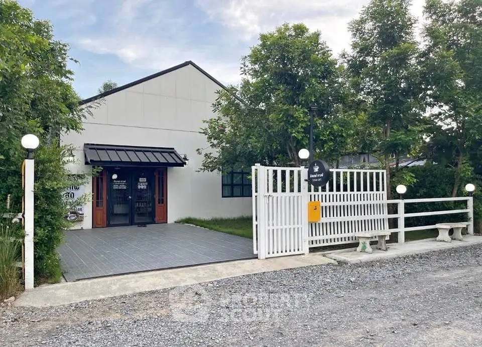 Charming modern house with white facade and lush greenery, perfect for serene living.