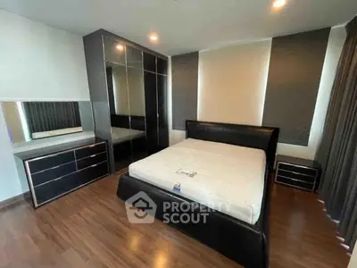 Modern bedroom with sleek black furniture and hardwood floors