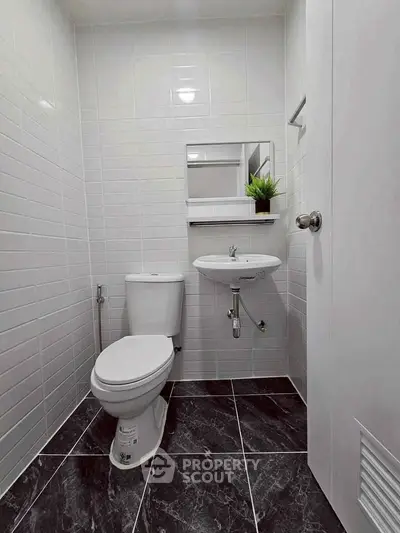 Modern bathroom with sleek fixtures and stylish black tile flooring.