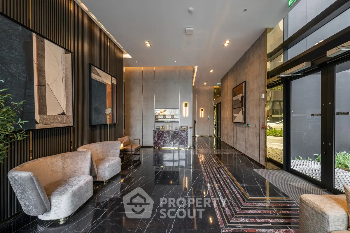 Luxurious modern building entrance with elegant marble flooring and stylish seating area.