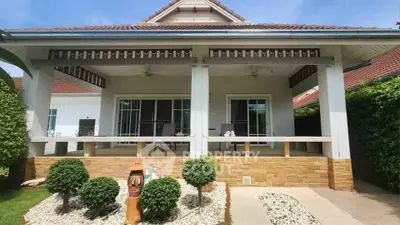 Charming single-story house with spacious patio and manicured garden, perfect for outdoor relaxation.
