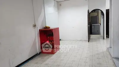 Spacious interior with tiled flooring and unique red cabinet, ideal for creative renovation.